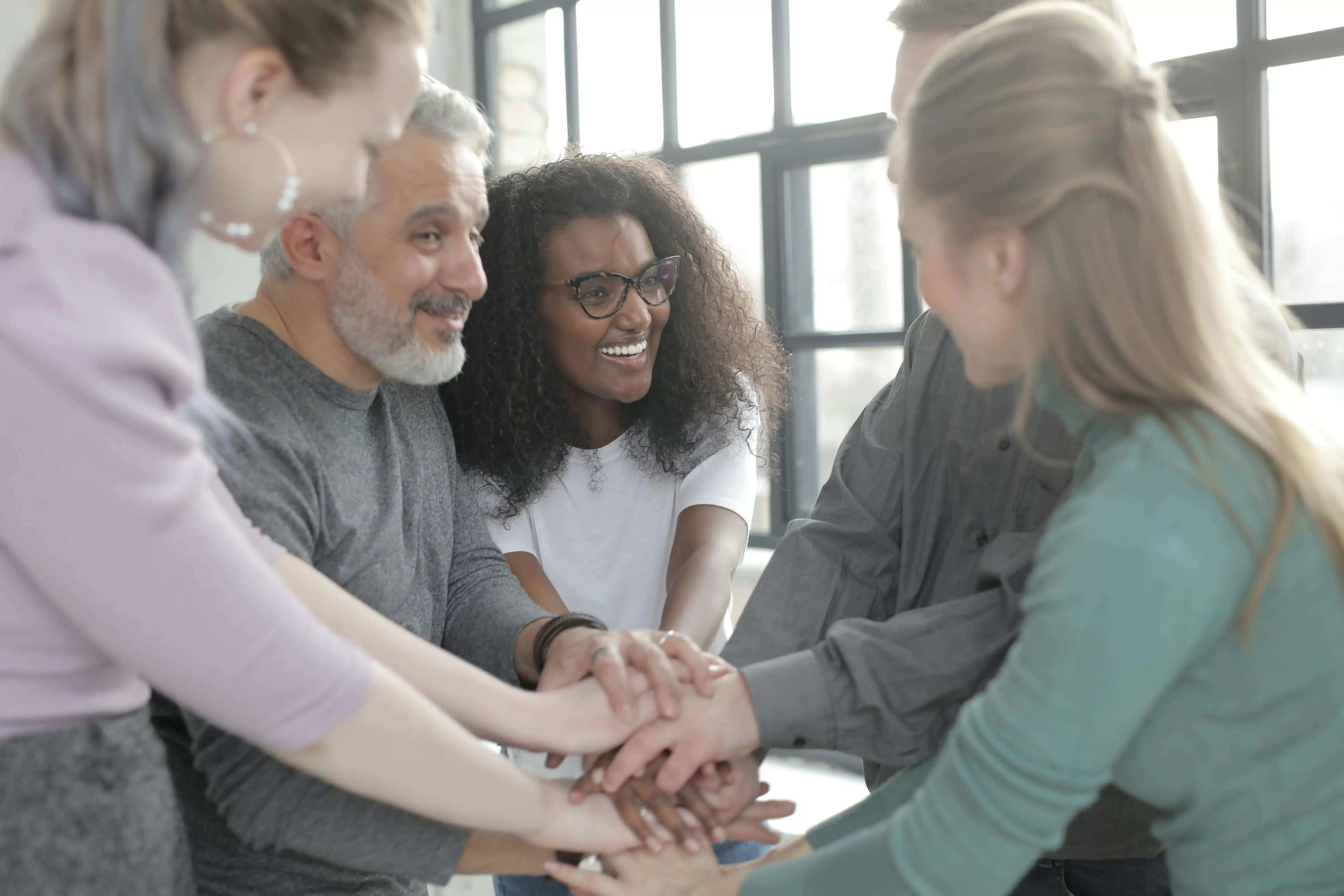 People holding hands in a support group circle.